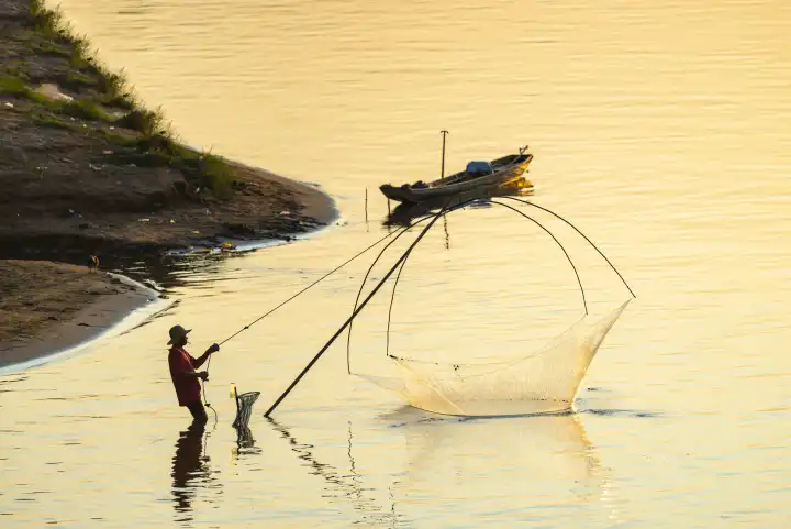 Fischer mit Senknetz bei Sonnenuntergang am Mekong, Luang Prabang, Laos, Asien