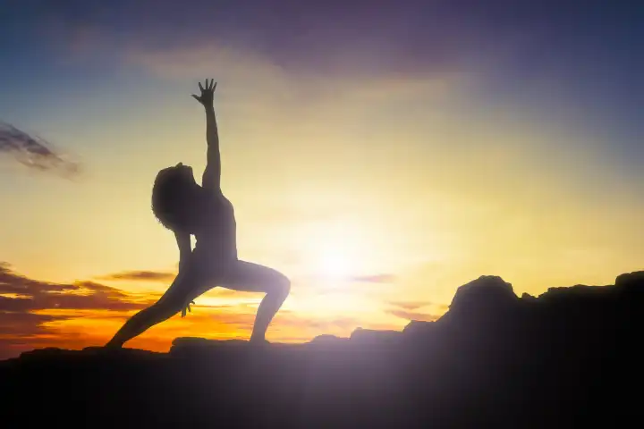 An image of a pretty woman doing yoga at sunrise