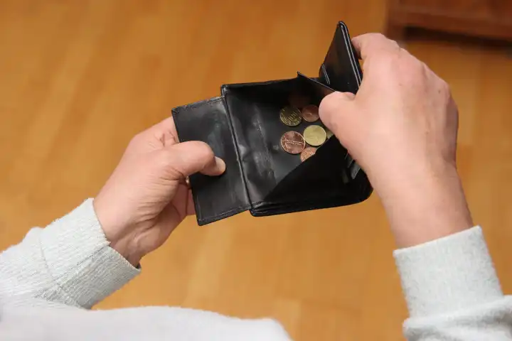 Frau zeigt ihr leeres Portemonnaie