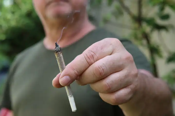 A man holds a joint between his fingers