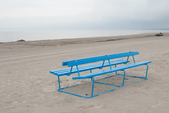 Blue park bench at the beach