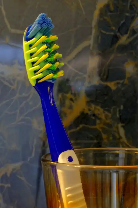 Blue and white toothbrush in glass