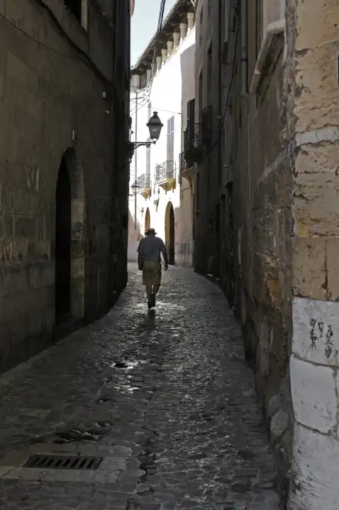 Mann geht durch eine enge Gasse, Palma, Mallorca, Spanien