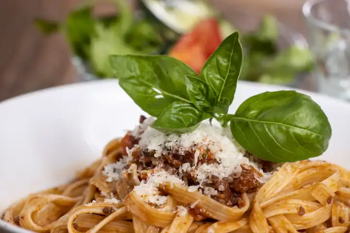 Tagliatelli pasta with bolognaise sauce on wood