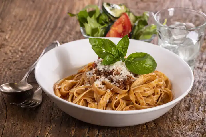 Tagliatelli pasta with bolognaise sauce on wood