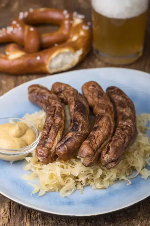 Nürnberger Würstchen mit Sauerkraut auf dem Teller 
