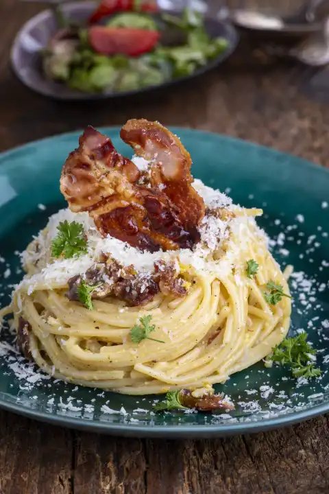 Spaghetti Carbonara mit Salat auf Holz 