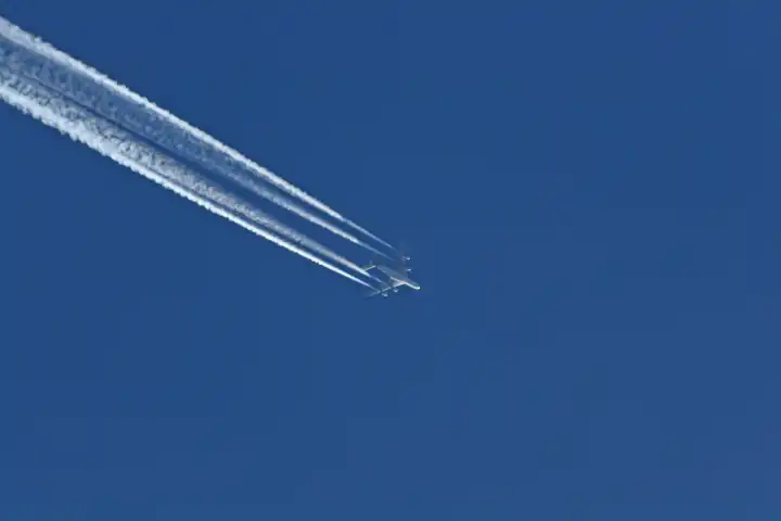 Jet with vapor trail at deep blue sky