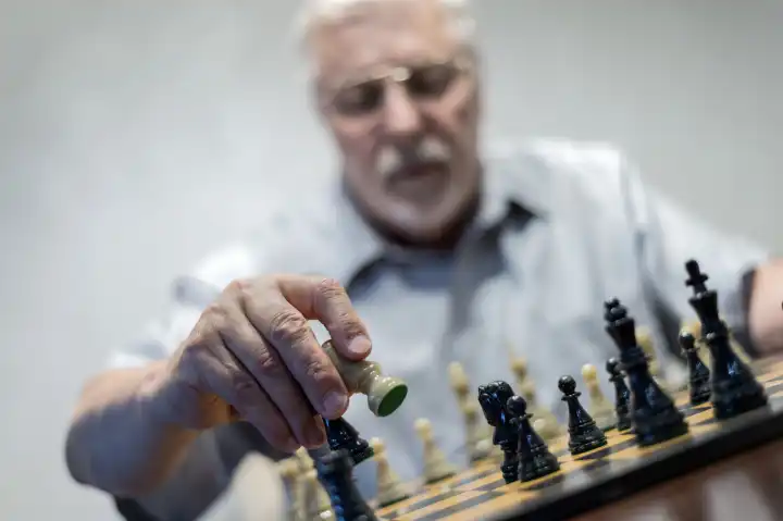ein Senior führt einen Schachzug aus