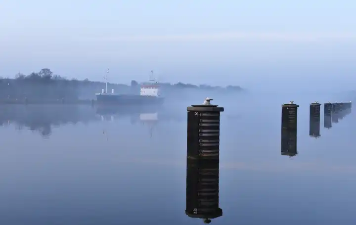 Frachtschiff fährt bei Nebel im Nord-Ostsee-Kanal