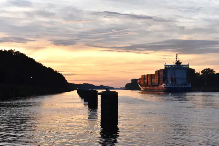 Containerschiff bei Sonnenaufgang im Nord-Ostsee-Kanal