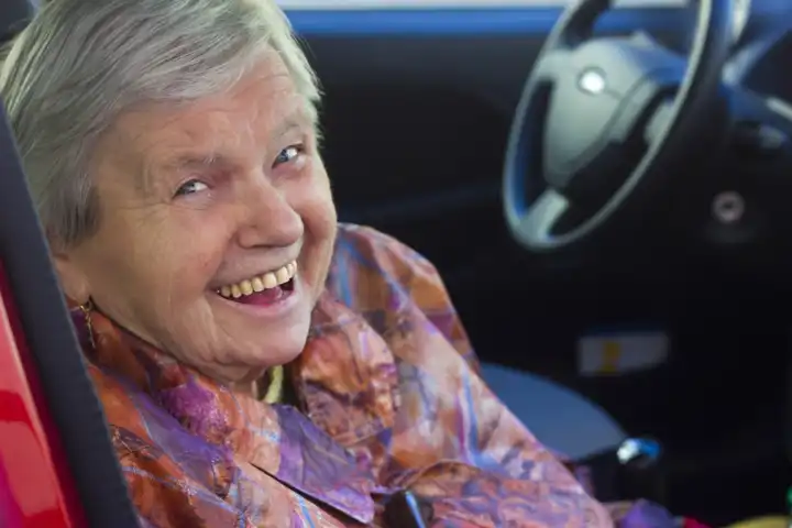 Lachende Seniorin als Beifahrerin im Auto