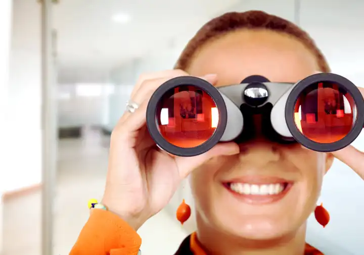 business woman searching for a job in an officelooking through binoculars