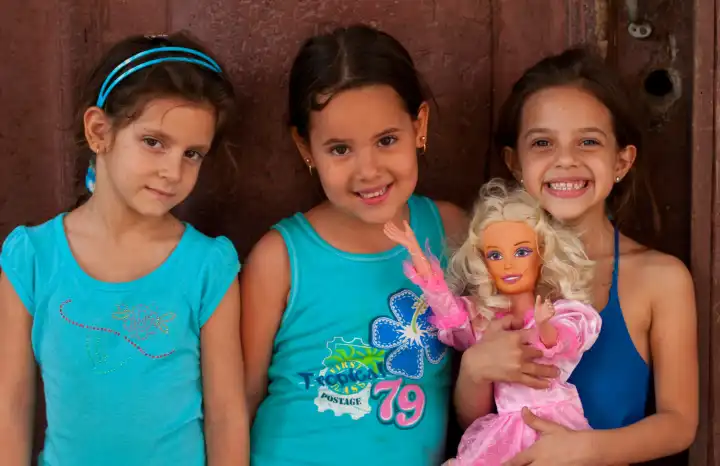 Oportrait of three young girls aged 6 with doll in Old Havana Habana Cuba