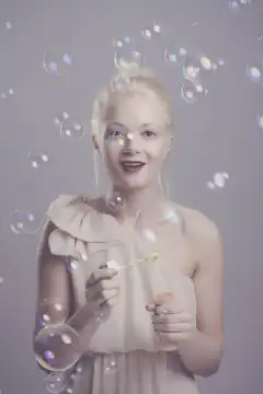 Junge, blonde Frau mit Seifenblasen