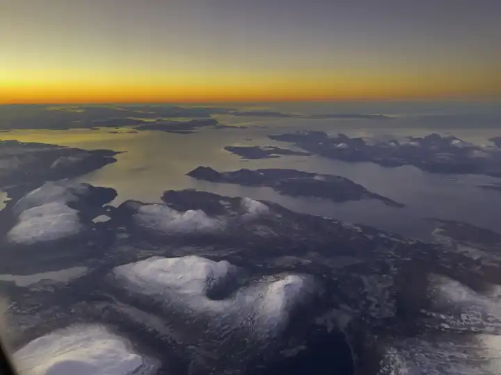 Arctic coastal landscape at dusk , flight above the clouds,