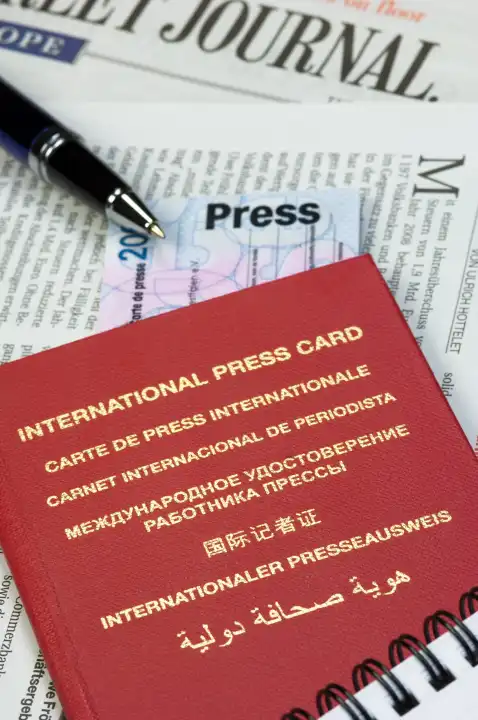 Internationaler und nationaler Presseausweis auf einer Zeitung liegend