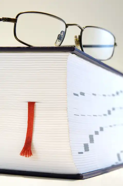 Reading glasses on a thick book
