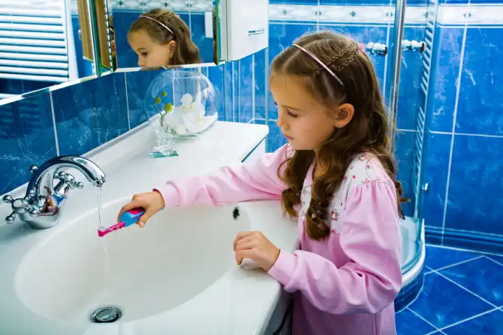 young girl with tooth-brush in front of mirror