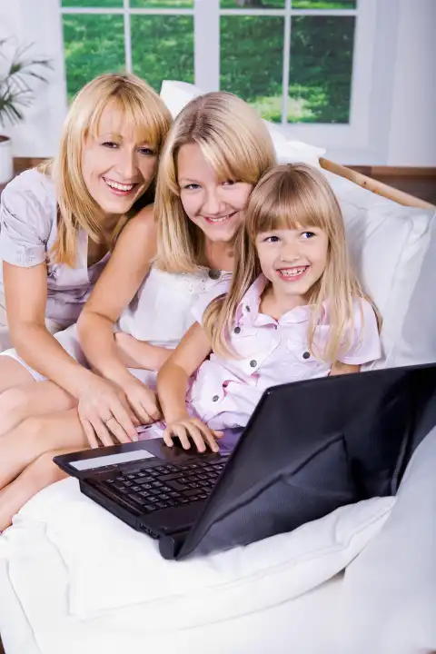mom and daughters working with a laptop