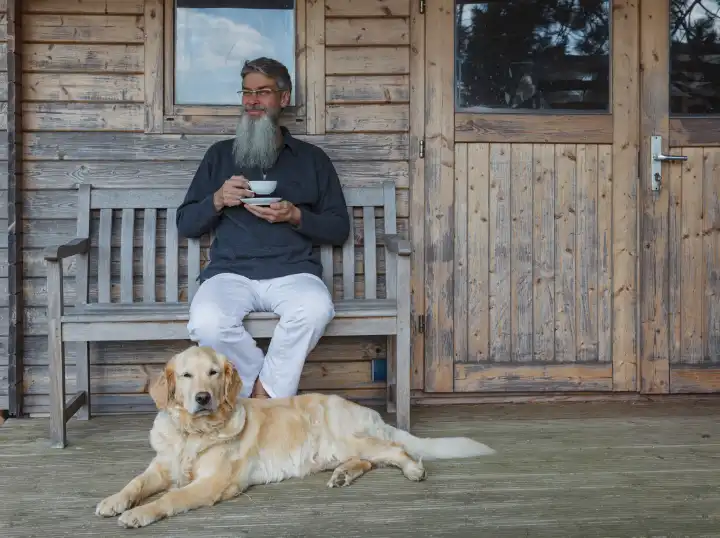 Mann mit Hund trinkt eine Tasse Tee