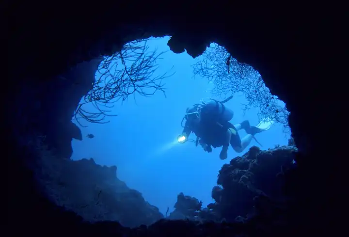 Taucher am Eingang einer Unterwasserhöhle
