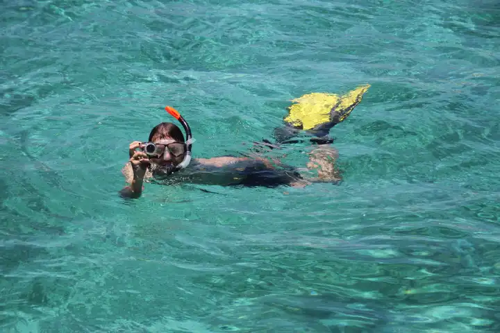 Mann fotografiert beim Schnorcheln im Indischen Ozean
