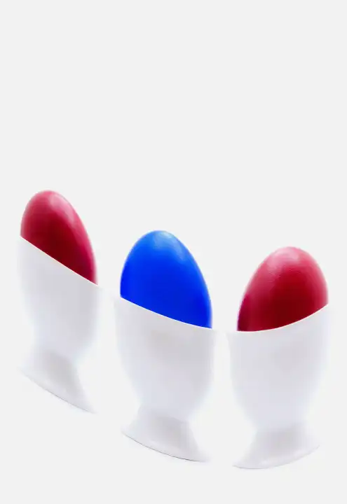 colored eggs in white egg cups distorted