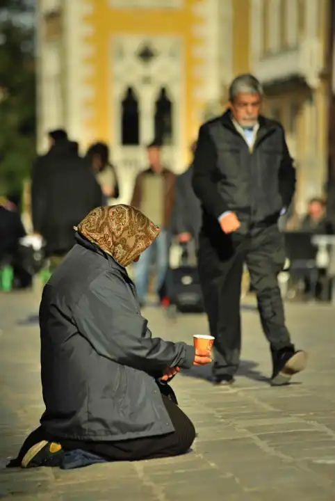 kneeling beggar on busy street in venice