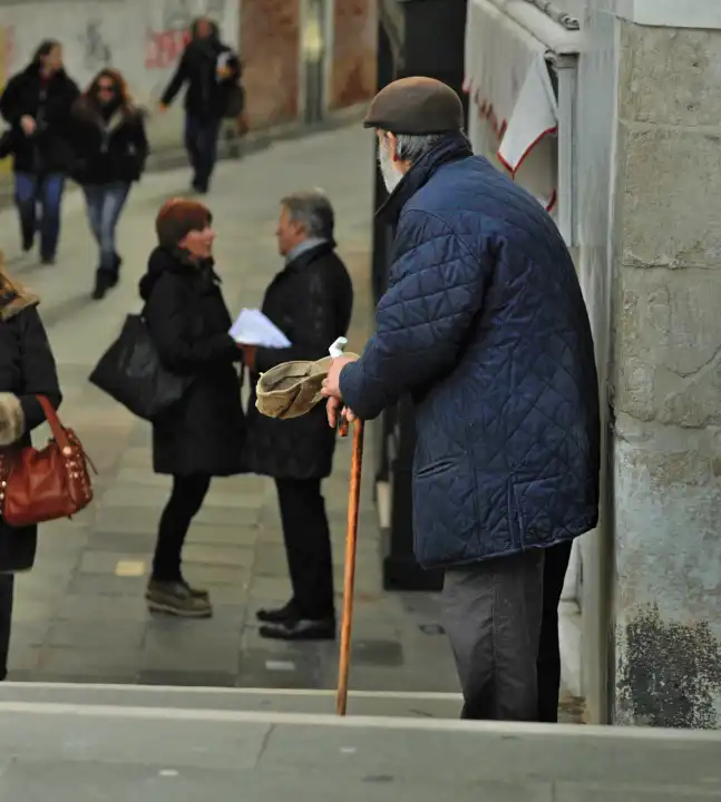 old beggar man on busy street in venice