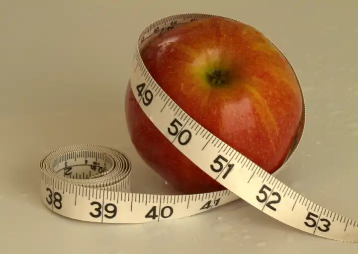 red apple with measuring tape to stay slim