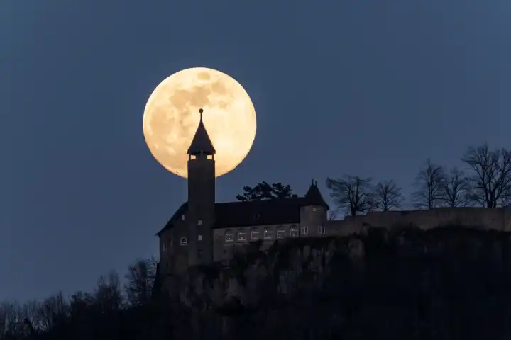 full moon behind castle teck