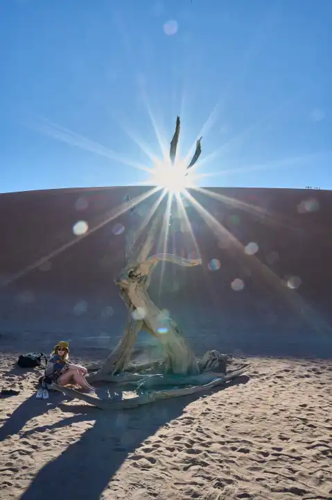 Junge Frau im starken Gegenlicht in der Wüste