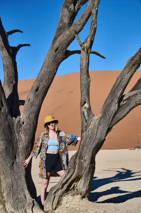Young woman in front of a tree in Deadvlei, Namibia