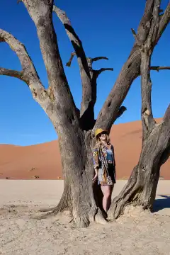 Junge Frau vor altem Baum im Deadvlei, Namibia