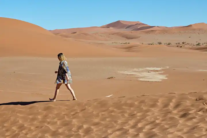 Junge Frau im Sand einer Wüstenlandschaft