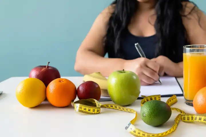 Nutritionist desk with healthy fruit, juice and measuring tape. Nutritionist working on diet plan. Weight loss and proper diet concept., generated with AI
