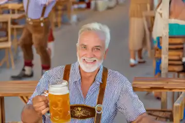 Mann hält auf dem Oktoberfest ein Maß Bier in der Hand,  KI generiert,