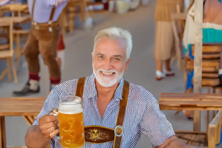 Man holding a pint of beer at the Oktoberfest, AI generated,