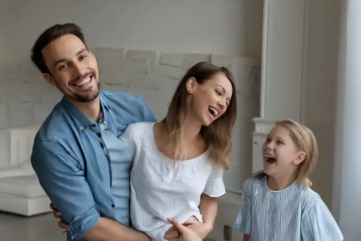 Eine Familie mit Kind lachen im Wohnzimmer, KI generiert,