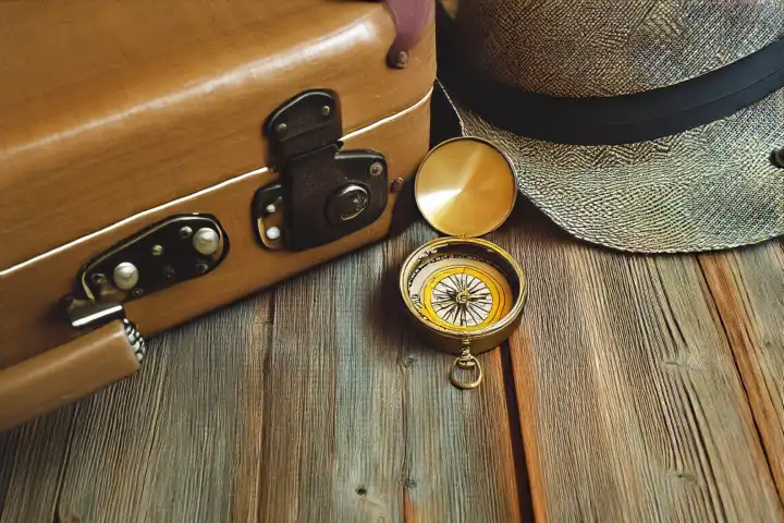 Traveler vintage luggage and compass on wooden table. Explorer and adventure concept, AI generated,