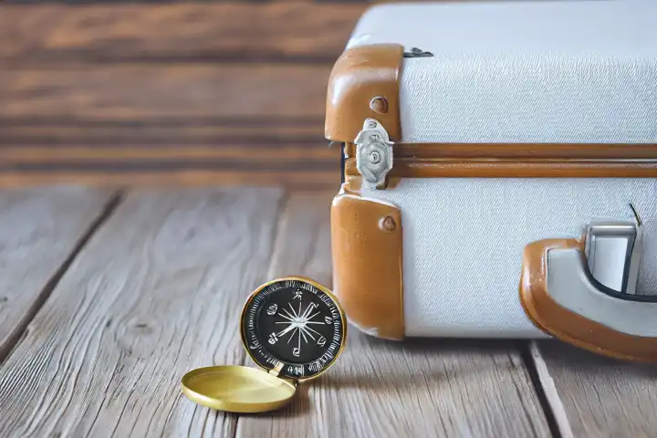 Traveler vintage luggage and compass on wooden table. Explorer and adventure concept, AI generated,