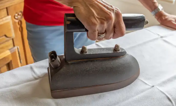 Women's hand ironing with a nostalgic old iron