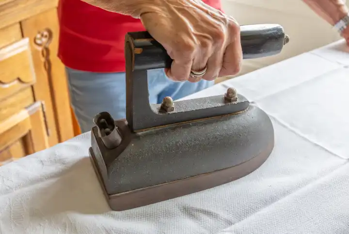 Women's hand ironing with a nostalgic old iron