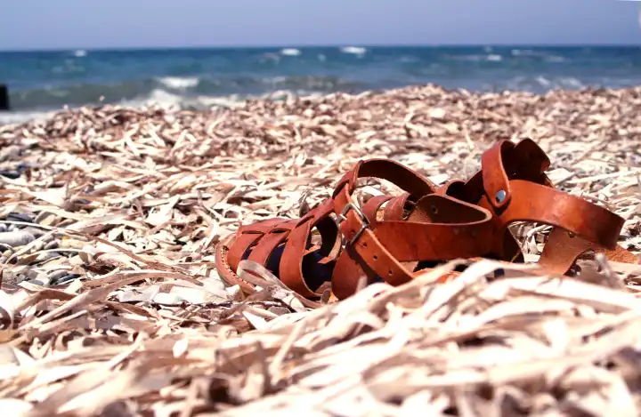 A pair of leather sandals on the beach