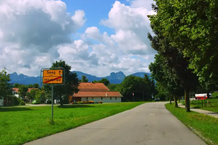 Road to Seeg in the Allgäu with a yellow town sign