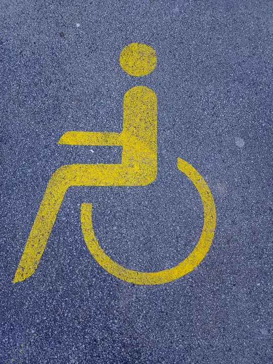 Sign for disabled persons on asphalt ground