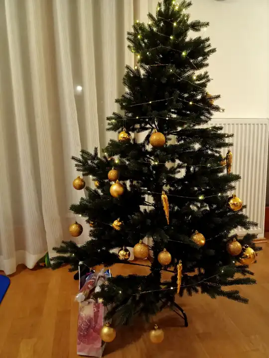Christmas tree with led yellow lights in a room.
