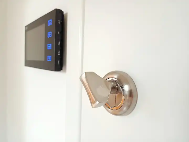 Sicherheitsschlüssel in einem schloss und lcdkameraüberwachungsbildschirm an einer wand