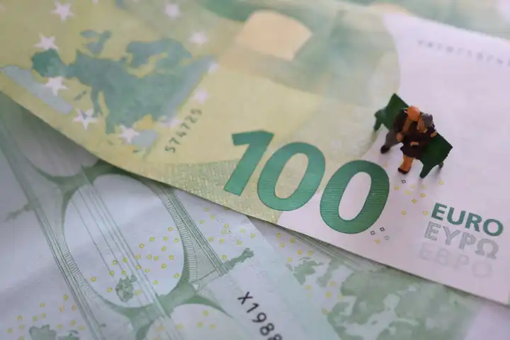 Miniatur-Senioren auf einer 100-Euro-Banknote. Ruhestand.